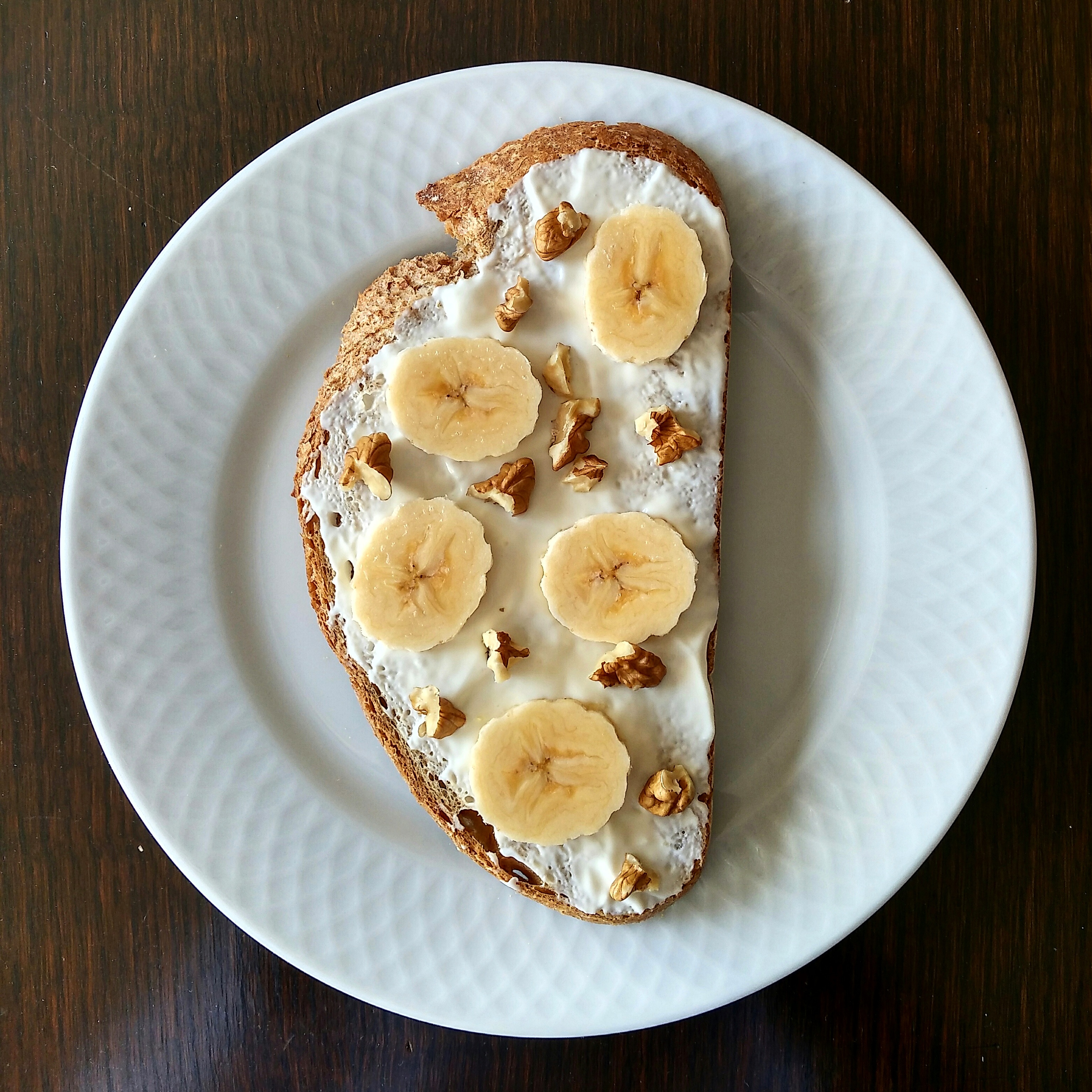 Tostada integral con queso crema, plátano y nueces